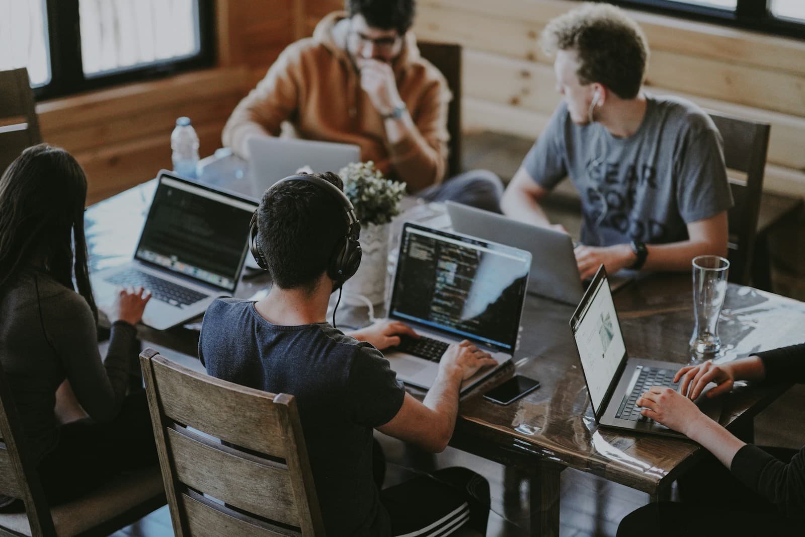 Students coding together on laptops around a shared table